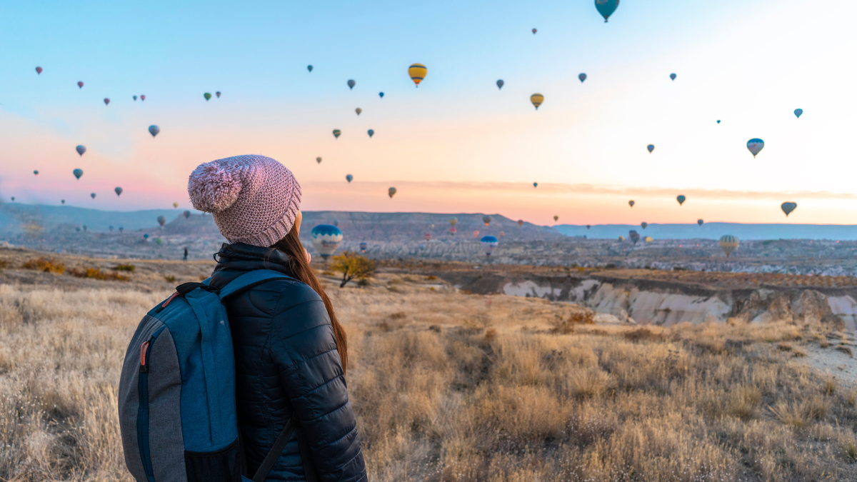 Woman looking over a field at hot air balloons in Turkey - explore 9 travel opportunities for teachers
