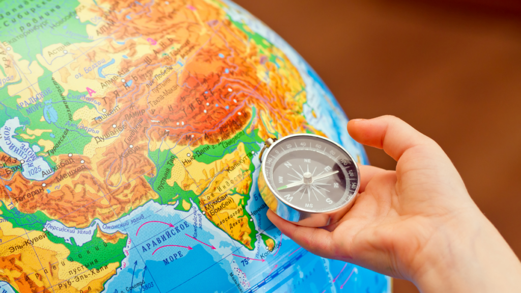 A child holding a compass over a globe