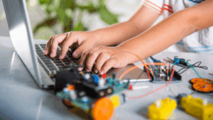 A child playing with a computer and robotic items for a blog post about data literacy for kids.